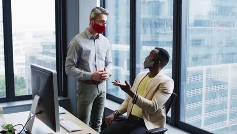 Diverse-Männliche-Bürokollegen-Mit-Gesichtsmasken-Diskutieren-Im-Modernen-Büro
