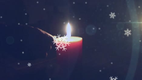 Animation-of-candle-being-lit-with-snow-falling-on-dark-background