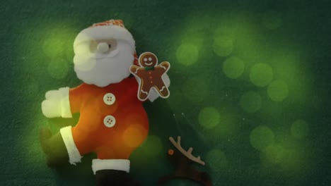 Animation-of-santa-claus-and-gingerbread-man-christmas-decoration-on-green
