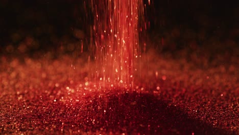Red-glitter-gems-spilling-on-black-background