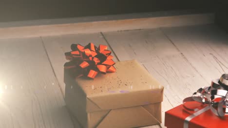 Animation-of-christmas-presents-on-wooden-surface-with-glowing-light
