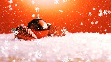 Animation-of-red-christmas-baubles,-snow-falling-on-red-background