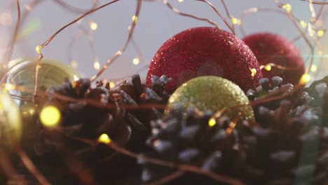 Animation-of-christmas-decorations-with-baubles,-lights-and-pine-cones