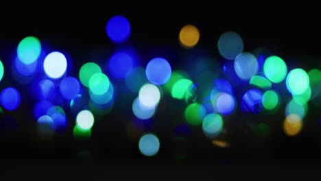 Multiple-blue-and-green-lights-flickering-on-black-background