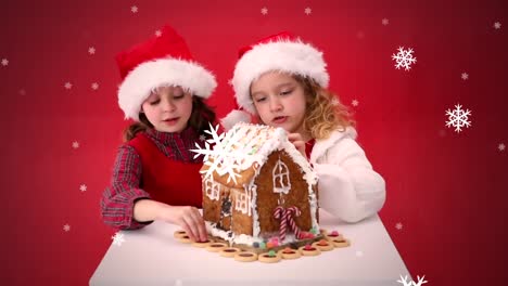 Animation-Von-Zwei-Mädchen-Mit-Weihnachtsmützen,-Die-Ein-Lebkuchenhaus-Dekorieren
