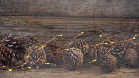Animation-of-pine-cones-christmas-decoration-over-wooden-surface