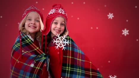 Animation-of-two-girls-in-woolen-hats-with-snow-falling-on-red