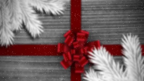 Animation-of-christmas-decoration-with-branches,-red-ribbon-and-snow-falling