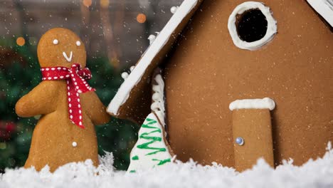 Animation-of-christmas-gingerbread-snowman-and-house-with-snow-falling