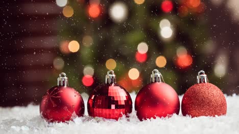 Animation-of-four-red-christmas-baubles-decoration-with-snow-falling