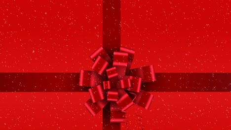 Animation-of-red-christmas-present-ribbon-with-snow-falling-on-red