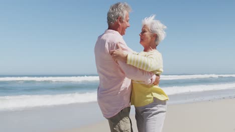 Glückliches-älteres-Kaukasisches-Paar,-Das-Beim-Tanzen-Am-Strand-Miteinander-Redet