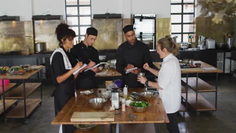 Caucasian-female-chef-teaching-diverse-group