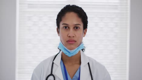 Porträt-Einer-Ärztin-Gemischter-Rasse,-Die-Eine-Gesichtsmaske-Aufsetzt