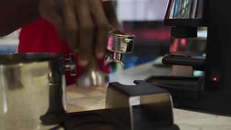 Mittelteil-Eines-Afroamerikanischen-Männlichen-Barista,-Der-Kaffee-In-Der-Kaffeemaschine-Zubereitet