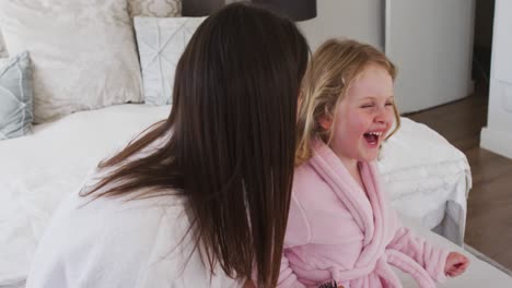Caucasian-mother-and-daughter-having-fun-laughing-in-bedroom