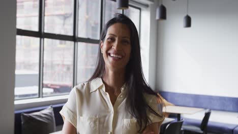 Portrait-of-happy-mixed-race-businesswoman-smiling-to-camera-in-office