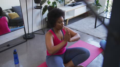 Mujer-Afroamericana-De-Talla-Grande-Sentada-En-Una-Colchoneta-De-Ejercicios-Meditando