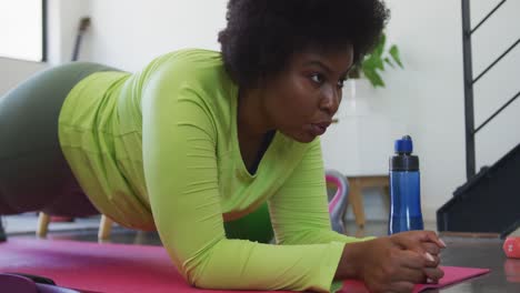 Afroamerikanische-Frau-In-Übergröße,-Die-Auf-Einer-Trainingsmatte-Liegt-Und-Trainiert