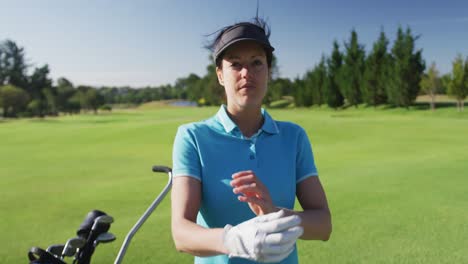 Portrait-of-female-caucasian-golf-player-crossing-her-arms-while-standing-at-golf-course