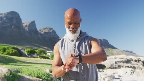Senior-african-american-man-exercising-using-smartwatch-listening-to-music