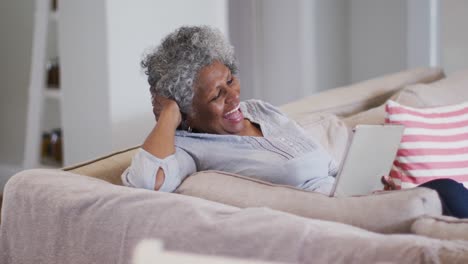 Ältere-Afroamerikanische-Frau-Lacht,-Während-Sie-Zu-Hause-Einen-Videoanruf-Auf-Einem-Digitalen-Tablet-Führt