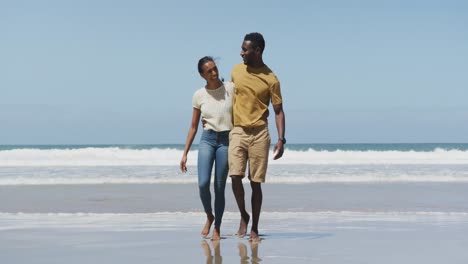 Glückliches-Afroamerikanisches-Paar,-Das-Sich-Umarmt-Und-Am-Strand-Spazieren-Geht