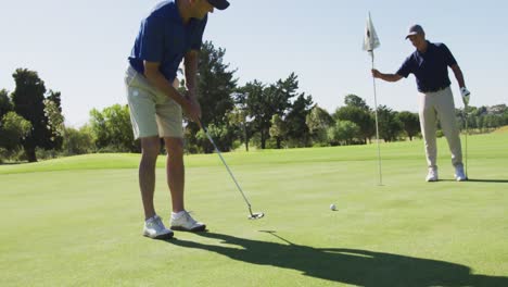 Dos-Hombres-Mayores-Caucásicos-Practicando-Golf-En-El-Campo-De-Golf-En-Un-Día-Soleado
