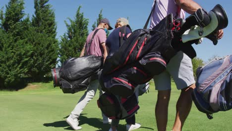 Ältere-Menschen-Mit-Gesichtsmasken-Gehen-Mit-Ihren-Golftaschen-Auf-Dem-Golfplatz