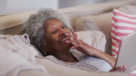 Ältere-Afroamerikanische-Frau,-Die-Zu-Hause-Einen-Videoanruf-Auf-Einem-Digitalen-Tablet-Führt