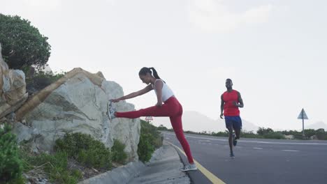 Diverse-fit-couple-exercising-stretching-and-running-on-a-country-road