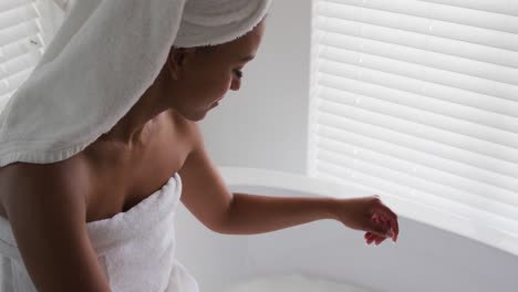 Afroamerikanische-Frau-Berührt-Wasser-In-Der-Badewanne-Im-Badezimmer-Zu-Hause