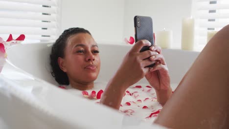 Afroamerikanische-Frau-Benutzt-Smartphone-In-Der-Badewanne-Im-Badezimmer-Zu-Hause