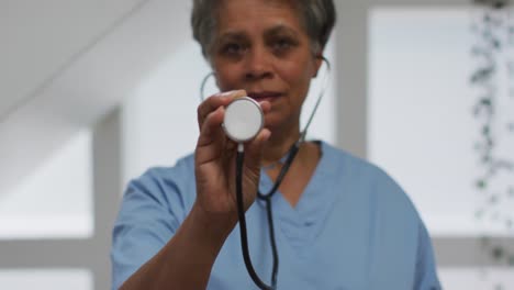 Portrait-of-senior-african-american-female-doctor-holding-stethoscope-looking-at-camera