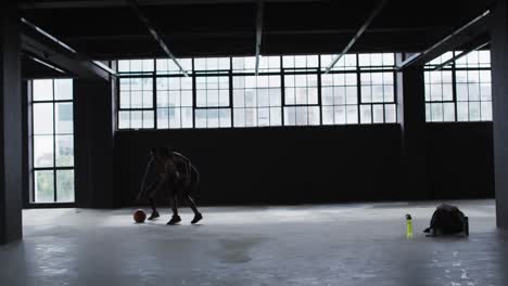 African-american-man-and-woman-standing-in-an-empty-building-playing-basketball