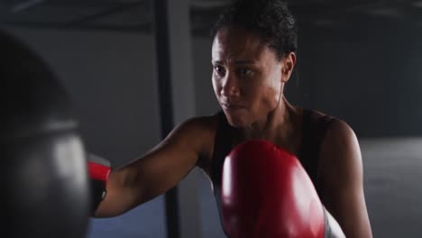 Afroamerikanische-Frau-Mit-Boxhandschuhen-Trainiert-In-Leerem-Gebäude-Und-Schlägt-Boxsack