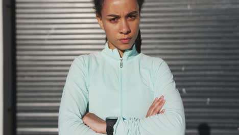 Portrait-of-african-american-woman-in-sportswear-with-arms-crossed-in-street