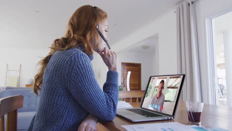 Kaukasische-Frau-Nutzt-Laptop-Und-Telefon-Headset-Bei-Einem-Videoanruf-Mit-Einem-Männlichen-Kollegen