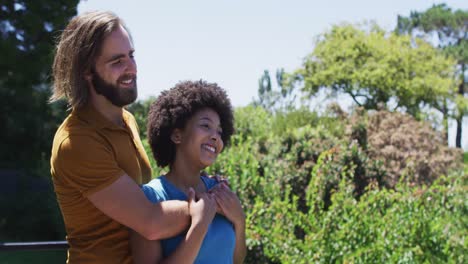 Mixed-race-couple-embracing-each-other-and-enjoying-the-view-while-standing-in-the-balcony-at-home