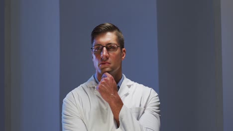 Caucasian-male-doctor-wearing-glasses-looking-at-information-using-virtual-digital-interface