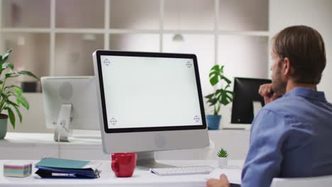 Kaukasischer-Mann-Benutzt-Computer,-Während-Er-Im-Büro-Auf-Seinem-Schreibtisch-Sitzt