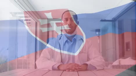 Animation-Der-Flagge-Der-Slowakei-Mit-Maskiertem-Männlichen-Arzt-Am-Schreibtisch,-Der-Eine-Videoberatung-Gibt