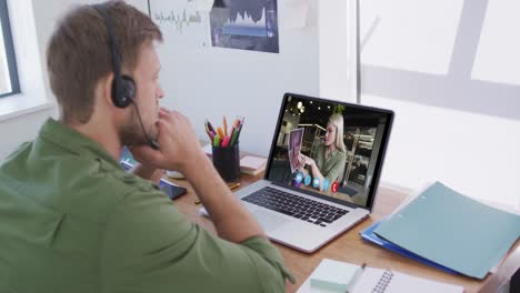 Caucasian-man-using-laptop-and-phone-headset-on-video-call-with-female-colleague