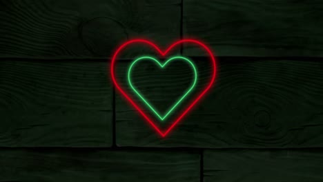 Animation-of-red-and-green-concentric-neon-hearts-flashing-on-dark-wood-boards
