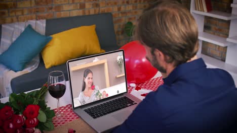 Caucasian-couple-on-a-valentines-date-video-call-smiling-woman-on-laptop-screen-holding-rose