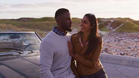 Afroamerikanisches-Paar-Umarmt-Sich,-Während-Es-Auf-Der-Straße-Neben-Dem-Cabrio-Steht