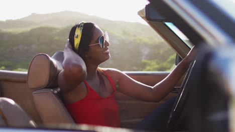 Portrait-of-african-american-woman-sitting-in-the-convertible-car-on-road