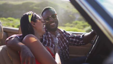 African-american-couple-talking-to-each-other-while-sitting-in-convertible-car-on-road