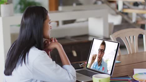 Caucasian-woman-using-laptop-on-video-call-with-male-colleague-working-from-home