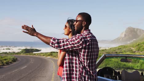 African-american-couple-embracing-each-other-while-standing-near-convertible-car-on-road
